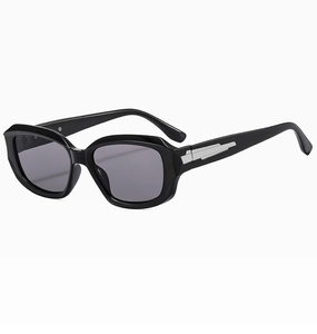 Close-up of black thick frame sunglasses with silver metal accents and grey lenses