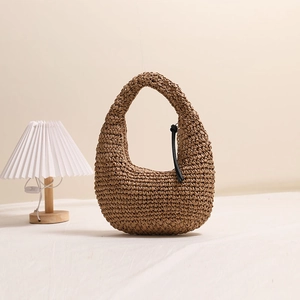 Brown handmade straw hobo bag with black knot detail for summer beach vacations