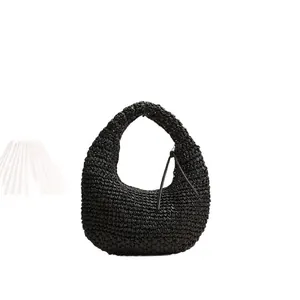 Handwoven black straw hobo bag with fringe tassel detail for beach vacation use