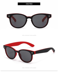 Detail der rot-schwarzen ovalen Sonnenbrille mit Metallnieten und dunklen Gläsern