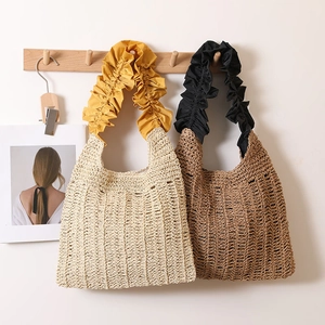 Japanese style woven straw tote bag with elegant ruffled handles for beach vacations