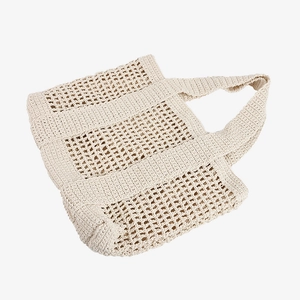 Large beige hand-woven crochet tote bag with hollow grid texture for beach vacations