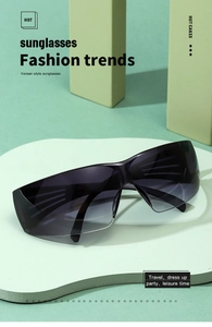 Close-up of oversized wrap-around Y2K sunglasses with gradient lenses on white pedestal