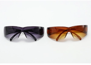 Detail of oversized rimless Y2K sunglasses in dark grey and orange outdoor sports lens