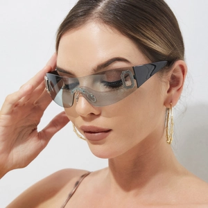 Detail of oversized rimless sunglasses featuring grey gradient lenses and metal accents