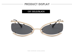 Détail de lunettes de soleil papillon évidées avec monture dorée et verres noirs