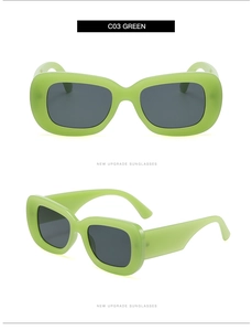 Detail view of fruit green retro sunglasses with thick frames and dark grey lenses