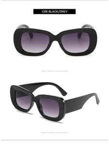 Detail view of wide-leg retro sunglasses with black frames and purple-grey gradient lenses