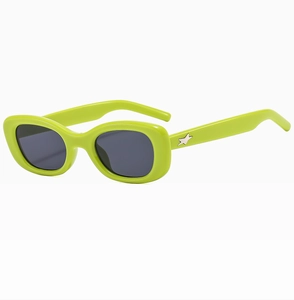 Détail de lunettes de soleil ovales vert fluo avec décoration d'étoile argentée sur la branche