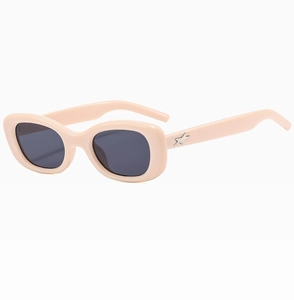 Détail de lunettes de soleil ovales avec monture crème et étoile argentée sur la branche