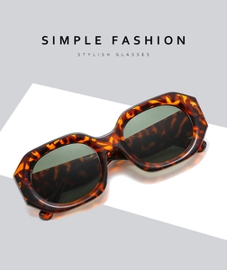 Close-up of tortoise shell pattern irregular hexagonal sunglasses with dark grey lenses