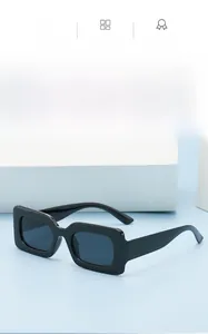 Close-up of stylish black square frame sunglasses with glossy finish on a blue background