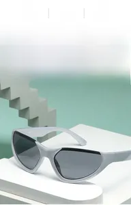 Vista dettagliata degli occhiali da sole Y2K argento su un supporto geometrico bianco