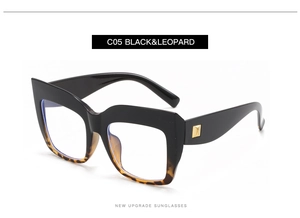 Detail of oversized square black and leopard print glasses with gold metal accents