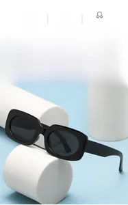 Detail of classic black square sunglasses with glossy wide frames on a white pedestal