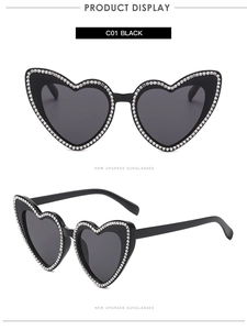 Détail de lunettes de soleil en forme de cœur avec monture noire et strass blancs