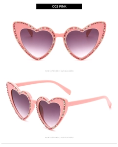 Détail de lunettes de soleil cœur rose avec monture ornée de strass et verres dégradés
