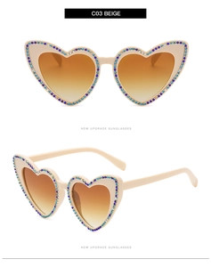 Détail de lunettes de soleil coeur beige avec strass bleus et transparents