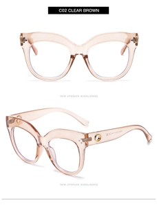 Detail view of oversized cat-eye glasses in clear brown with golden metal temple accents