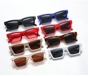 Flat lay of small rectangular vintage sunglasses in eight assorted colors on white background