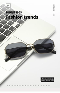 Detailed close-up of geometric gold metal frame sunglasses on a laptop keyboard