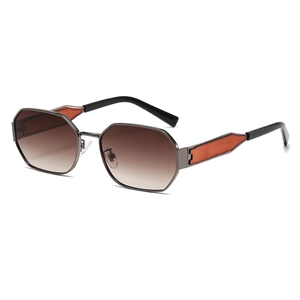 Detail of octagonal sunglasses showing dark metal frames and orange decorative inserts