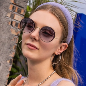 Detail of round rimless sunglasses with purple gradient lenses and heart-shaped inner frames