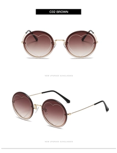 Detail view of brown gradient rimless sunglasses with gold frames and heart lens accents