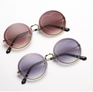 Detail of round rimless sunglasses with heart engraving and gradient lenses