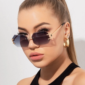 Detail of rimless octagonal sunglasses featuring gradient purple lenses and engraved gold arms