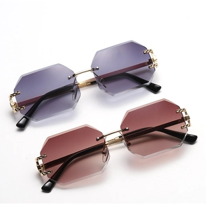 Detail of rimless octagonal sunglasses with purple and brown gradient lenses and gold bridge