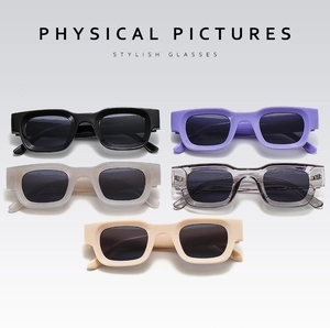 Flat lay of retro rectangle sunglasses in black, lavender, matte white, grey, and beige colors