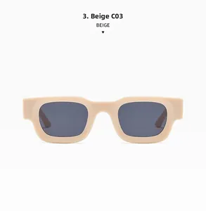 Detail view of beige rectangular punk sunglasses with dark grey lenses and wide temples