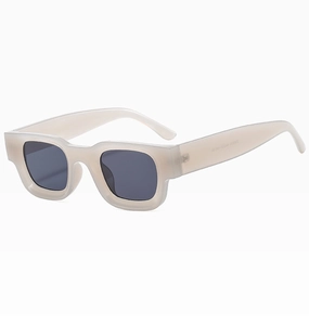 Detail view of cream acetate frame sunglasses with dark lenses and metal hinges