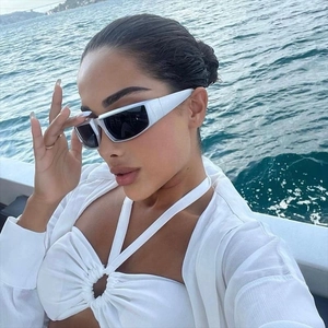 Gros plan de lunettes de soleil Y2K futuristes avec monture blanche sur un modèle