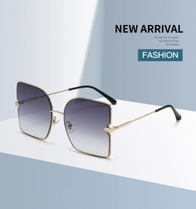 Gros plan de lunettes de soleil dorées avec verres dégradés violets sur supports