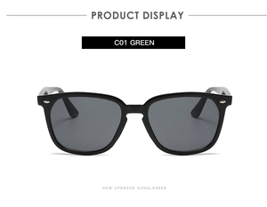 Detail of square black sunglasses with dark green lenses and silver rivet accents