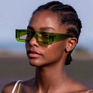 Close-up of translucent green rectangular sunglasses featuring a unique double-layer frame