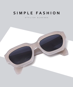 Close-up of stylish rectangular sunglasses with champagne frames and dark lenses