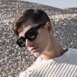 Futuristic polygon sunglasses with thick black frames worn by male model in outdoor setting
