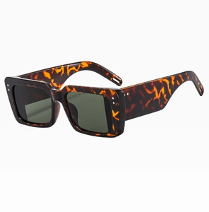 Close-up of retro square tortoiseshell sunglasses with dark green lenses and silver studs