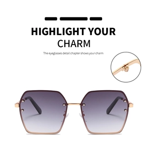 Detail of gold metal hinges and purple gradient lenses on oversized square sunglasses