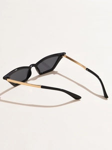 Detail of cat eye sunglasses showing golden metal temples and dark gray lenses
