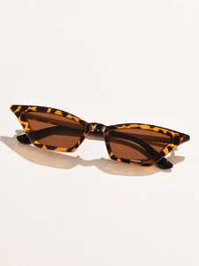 Detailed view of tortoise shell cat-eye sunglasses with dark brown lenses on white backdrop