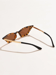 Detail of tortoise shell cat-eye frames with golden metal temples and brown UV lenses