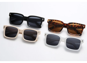Detail of square vintage sunglasses in black, tortoiseshell, cream and white with metal rivets