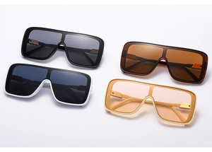 Detail view of four large square sunglasses in black, tea, white, and beige colors