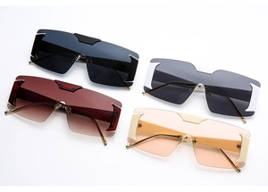 Detail view of four rimless oversized sunglasses in black, red, white and apricot colors