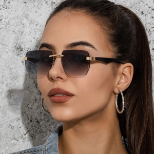 Close-up of rimless square sunglasses with gradient grey lenses and golden metal bridge