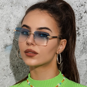 Gros plan sur un modèle portant des lunettes de soleil carrées sans monture bleues